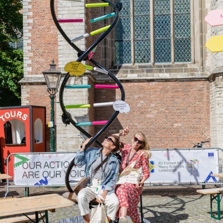 Two employees of Leiden2022 pose with the DNA statue outside of the Hooglandse Kerk